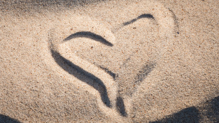 Fototapeta na wymiar Heart shape on sand on a beach