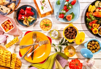 Tuinposter Colorful Mediterranean Meal on White Picnic Table © exclusive-design