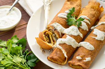 Pancake rolls with mushrooms and yogurt dip