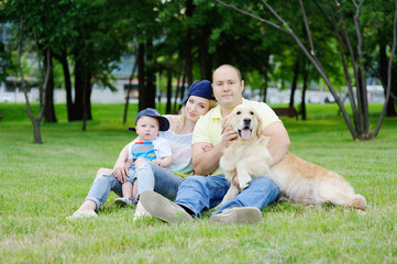 Fototapeta premium family with a dog retriever on the grass