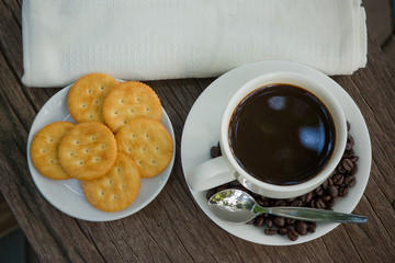 Cup of coffee on a wooden board and biscuits