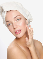 Portrait of beautiful girl touching her face with a towel on