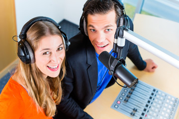 Moderatoren - Mann und Frau - oder Kollegen in Radiostation moderieren eine Sendung fürs Radio...