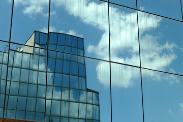 Fototapeta na wymiar Reflection in windows of modern office building