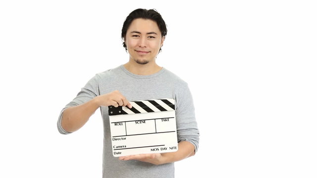 Man in a grey shirt holding a movie clapper, white background