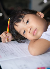 Cute asian girls is doing her homework.