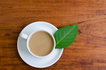 Cup of coffee and laptop on wooden table.
