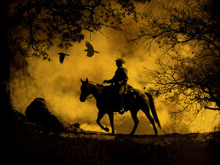 A dramatic design of a cowboy and his horse riding in a meadow into the sunset with crows flying above. A mixed media piece of artwork in photography and watercolor.