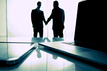 Fototapeta premium Computer on desk , businesspeople standing in the background