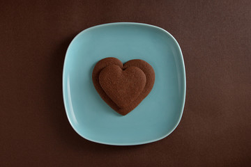 Two heart shaped chocolate cookies on a plate 