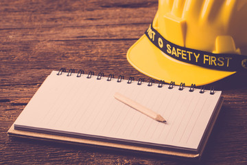 Yellow safety helmet on wood table.