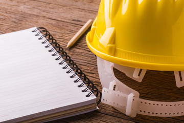 Yellow safety helmet on wood table.