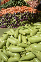 fresh zucchini and vegetables on a market stall 