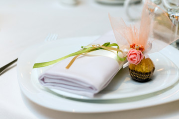 serviette and candy on a plate served on the festive table