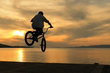 Fototapeta na wymiar Beautiful sunset and biker's tricks. 