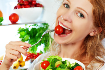 woman eats healthy food vegetable vegetarian salad about refrige
