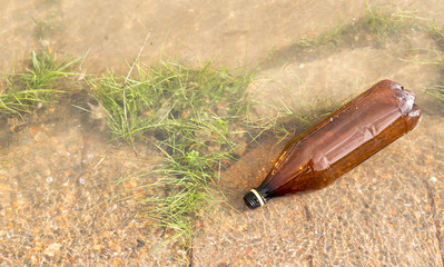 Brown Plastic Bottle in River
