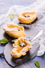 Delicious hot dessert: baked pears in pastry on rustic wooden background. Selective focus