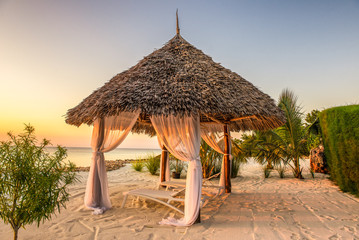 Beach lounge chairs at sunset, Zanzibar, Tanzania