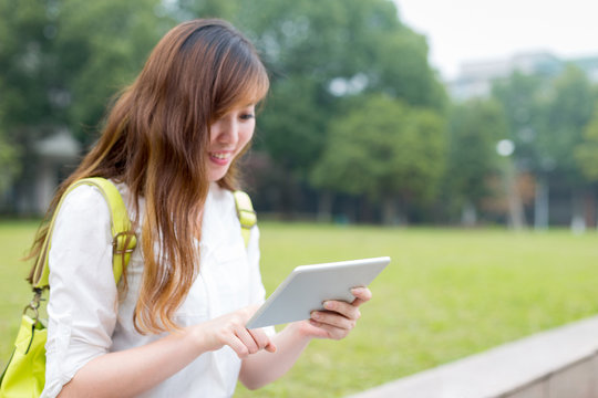 Asian Female Student Using Tablet In Campus