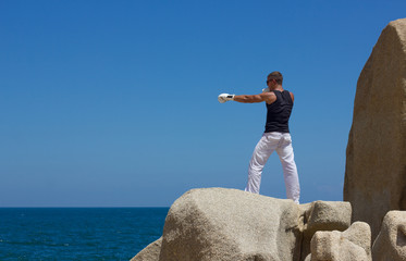 Молодой спортивный мужчина тренируется на море....