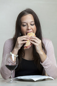 Young Woman Biting A Sandwich