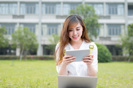 Asian female student using tablet in campus