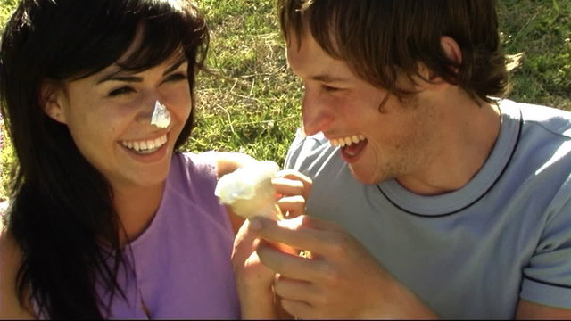 Young couple in park eating ice-cream