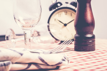 Obraz na płótnie Canvas Dinner table with alarm clock background.