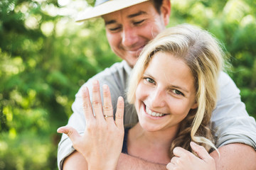 Happy blonde woman showing engagement ring