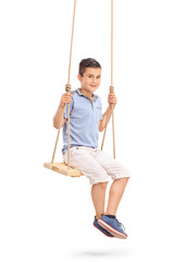 Joyful little kid sitting on a swing