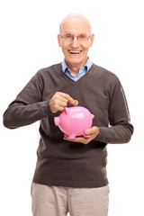 Joyful senior putting coin into a piggybank