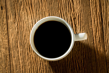 Top view of hot black coffee on wood table.