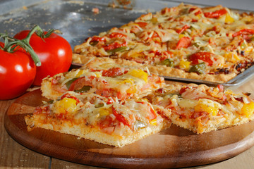 Pizza mit Paprika, Tomaten, Schinken, Zwiebeln, Käse