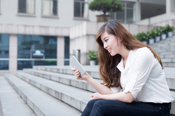 Fototapeta premium Asian female student using tablet in campus