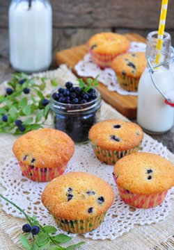 fresh muffins with blueberry and milk on wooden background