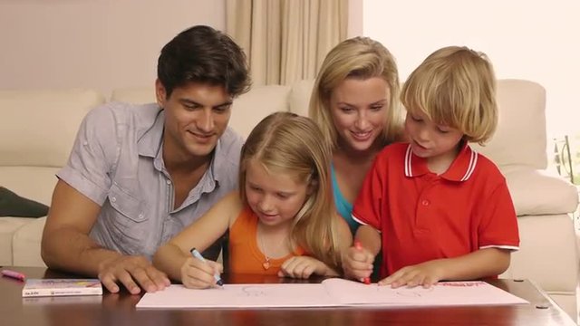 Family drawing and coloring together in living room.
