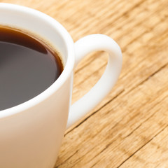 Neat cup of americano coffee on old wooden table