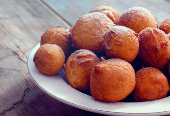 Sweet fried doughnuts sprinkled with sugar powder