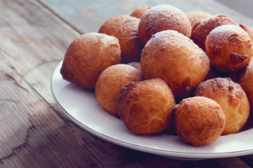 Sweet fried doughnuts sprinkled with sugar powder