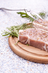 Fresh Raw Steak Meat with spaces, herbs and vegetables on wooden board, selective focus