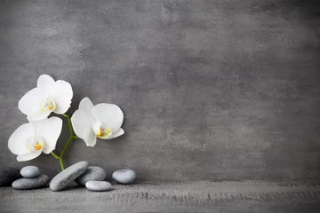 Plexiglas foto achterwand White orchid and spa stones on the grey background. © gitusik
