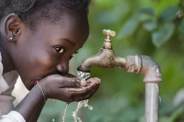 Foto op Canvas Social Issues: African Black Child Drinking Fresh Water From Tap © Riccardo Niels Mayer