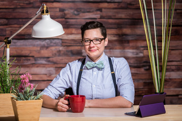 Dapper Woman in Stylish Office at Wood Desk with Mug