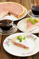 Strawberry tart with two cut pieces decorated with fresh mint an