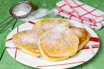 Fritter with powdered sugar - a traditional russian breakfast