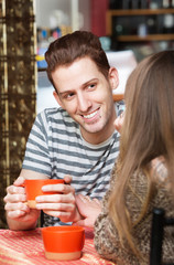 Smiling Man with Friend in Cafe