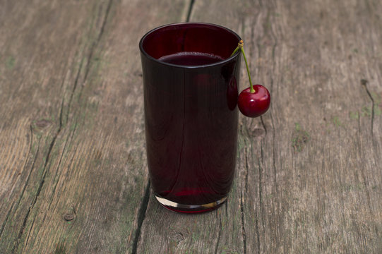 the glass of juice decorated with the hanging berry