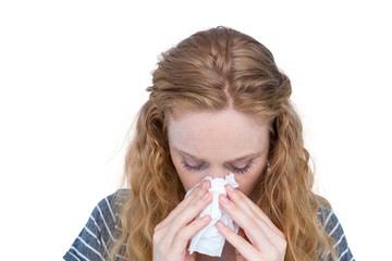 Sick blonde woman blowing her nose