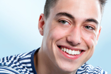 Handsome young man with healthy teeth looking aside.